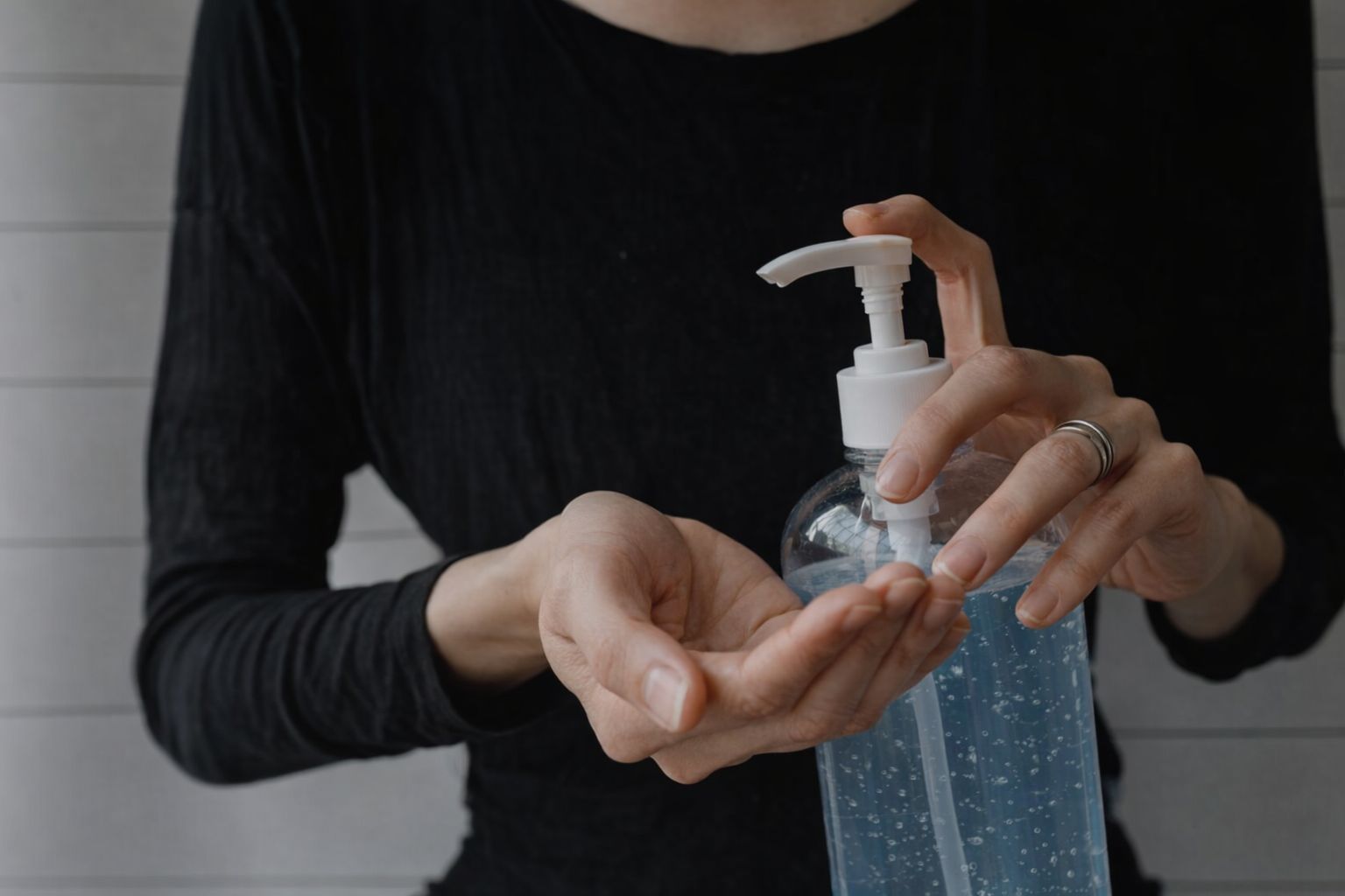 En person som använder handsprit från en pumpflaska för god hygien.