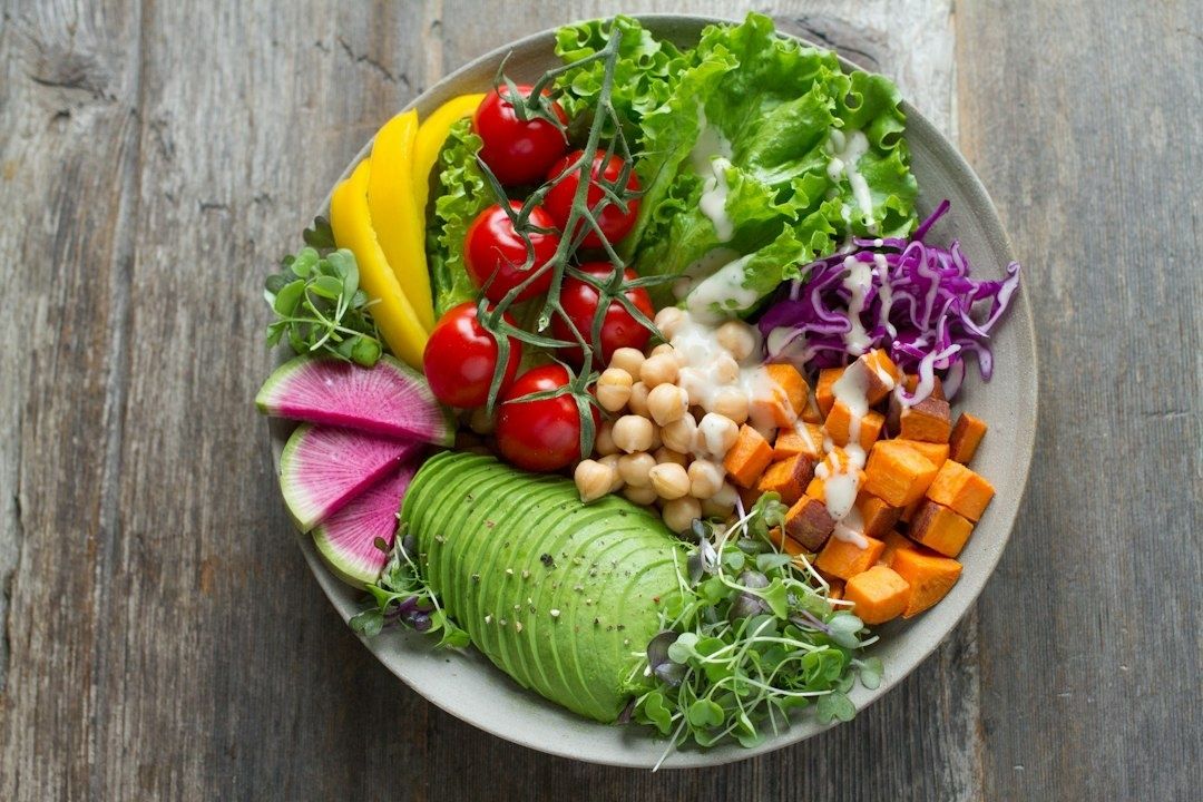 Färgstark salladstallrik med avokado, kikärter och grönsaker